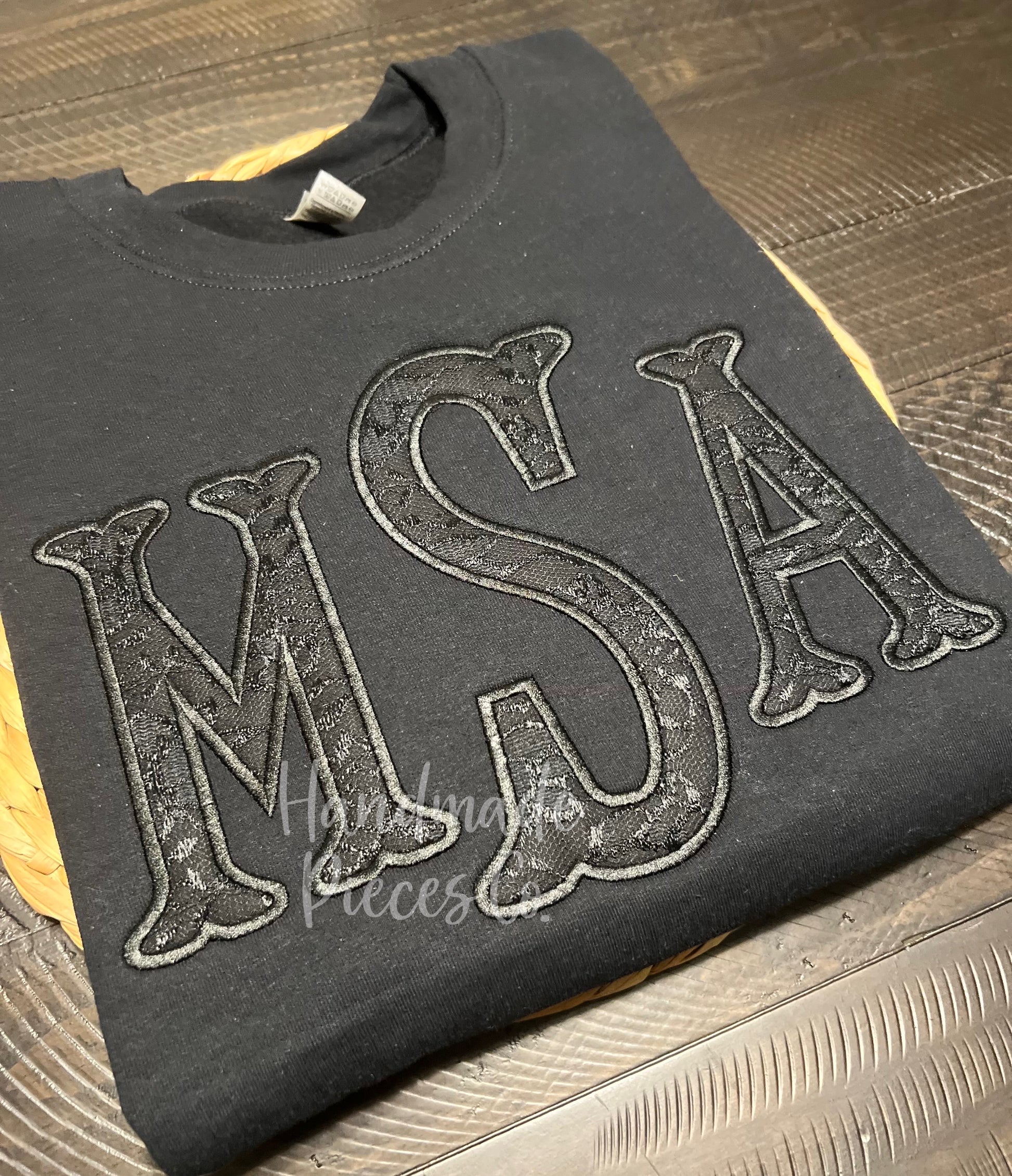 Black sweatshirt with 'MSA' lace embroidered on it